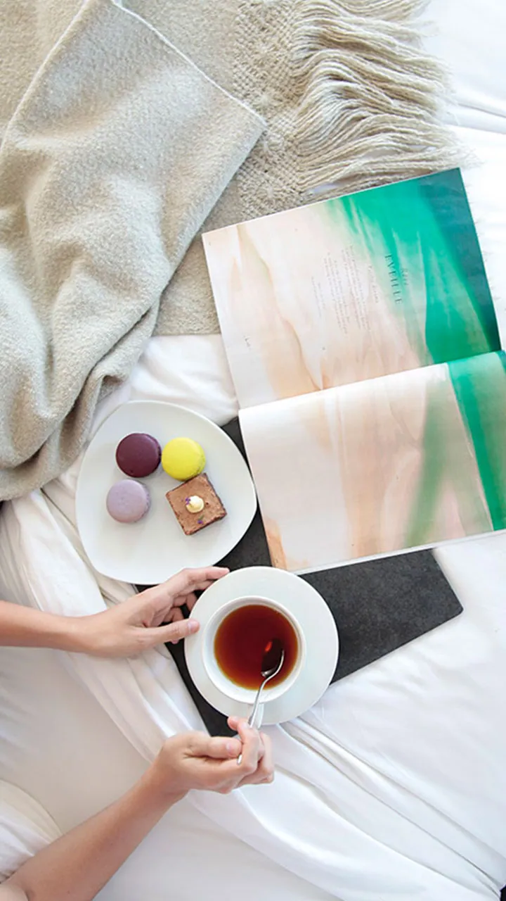 Desayuno y té servidos junto a una cama