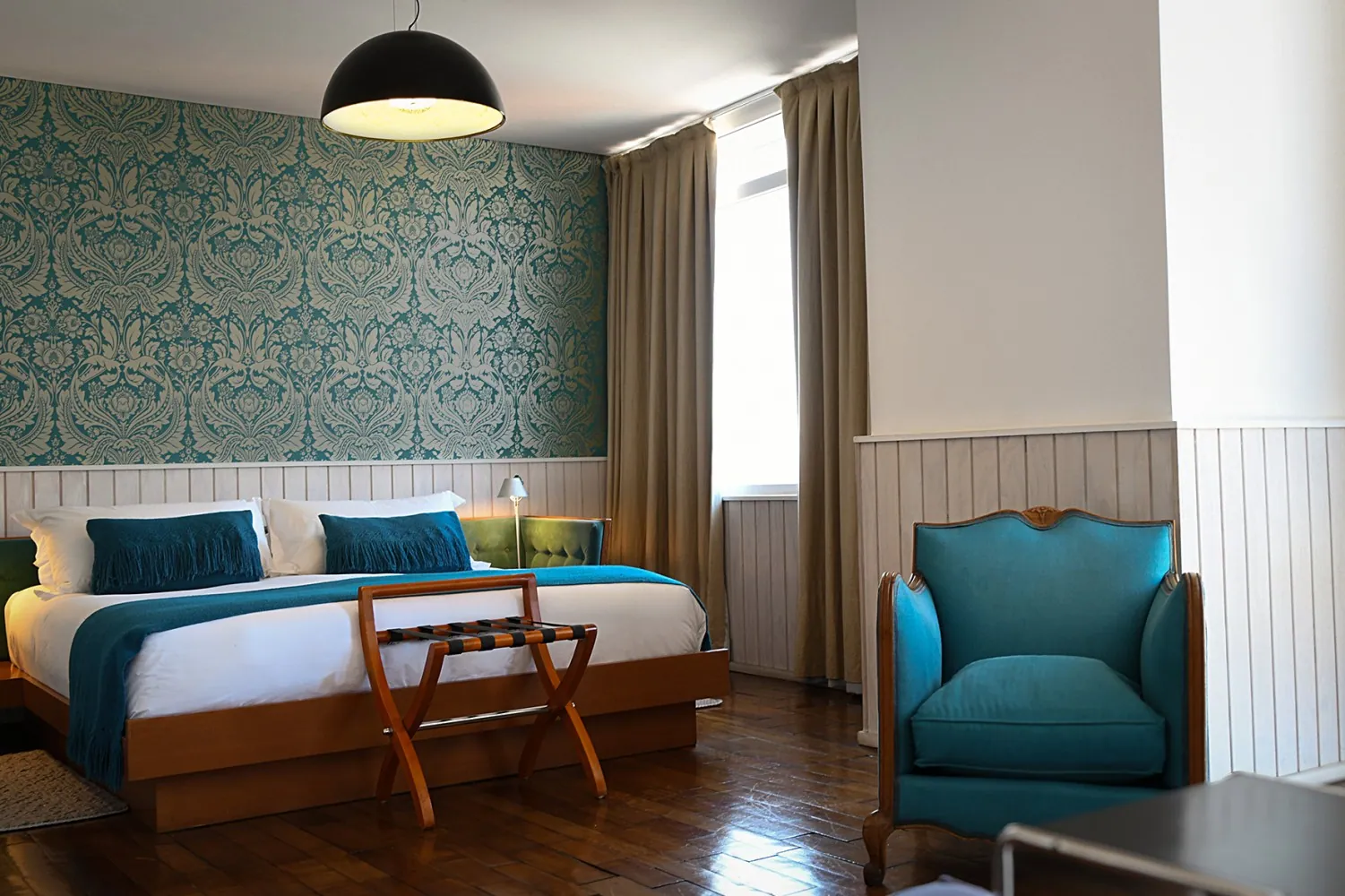 Junior Suite con papel mural, cama y sillón turquesa