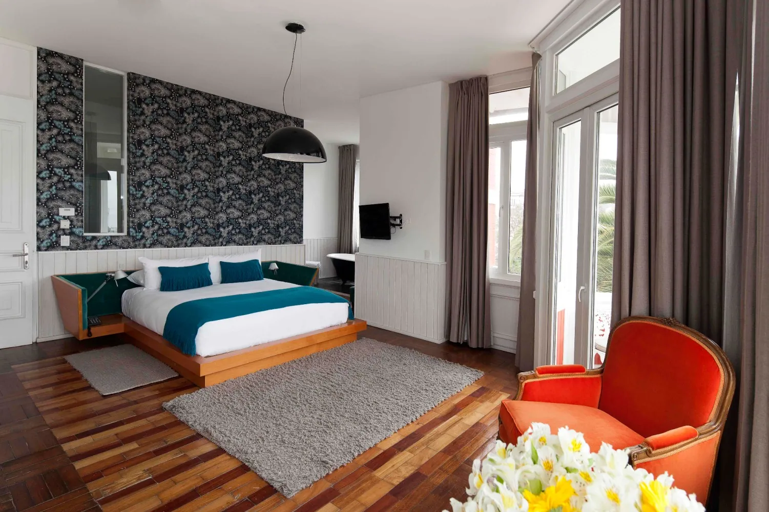 Vista amplia de cama y estar en Suite Deluxe