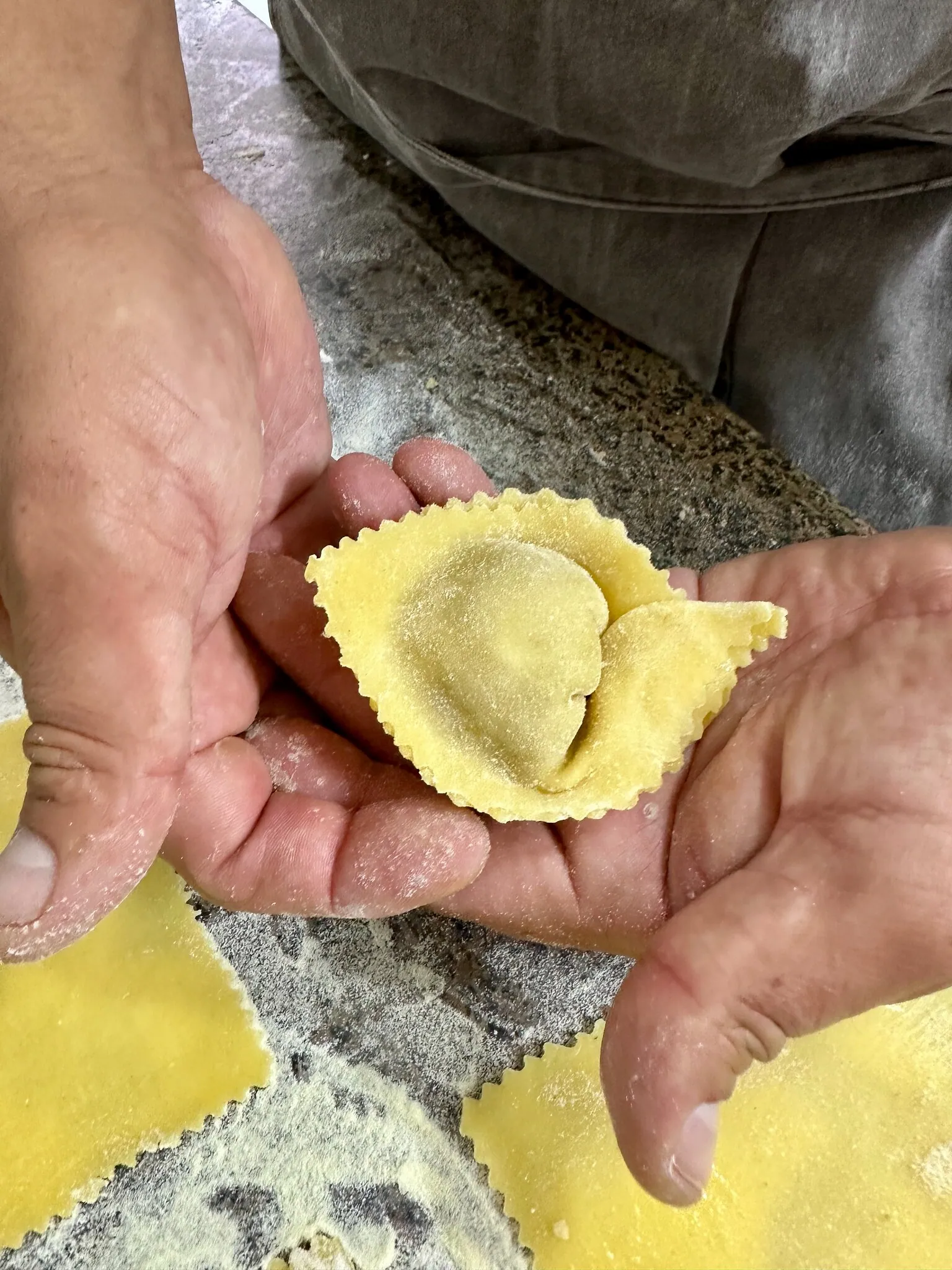 Manos cerrando un raviolo de pasta fresca en Pastalegre