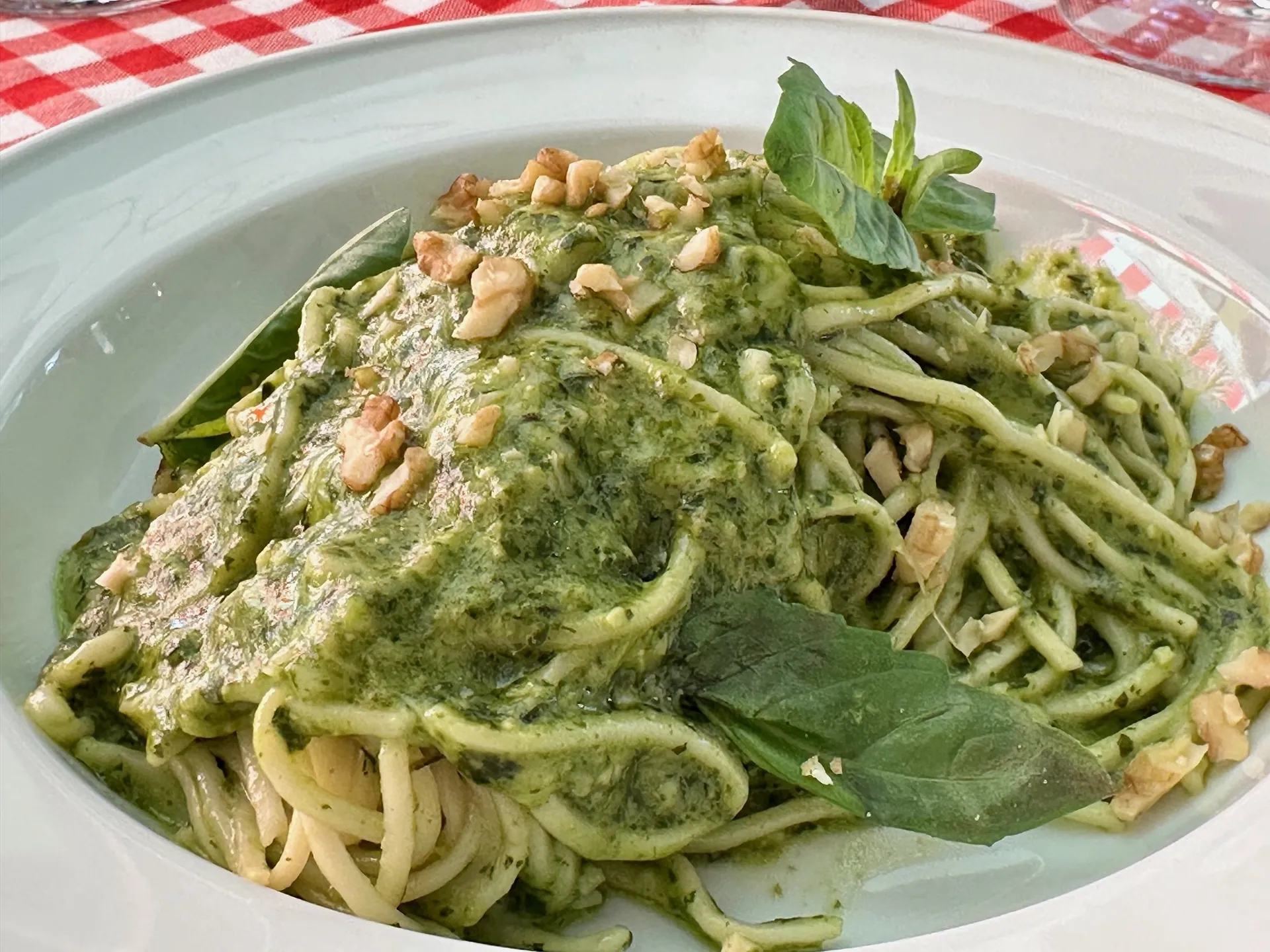 Spaghetti al pesto sobre un mantel a cuadros en Pastalegre