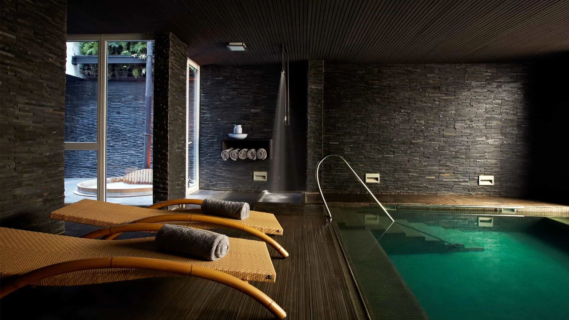 Zona de descanso junto a la piscina de Spa Alegre, con la tinaja visible al fondo