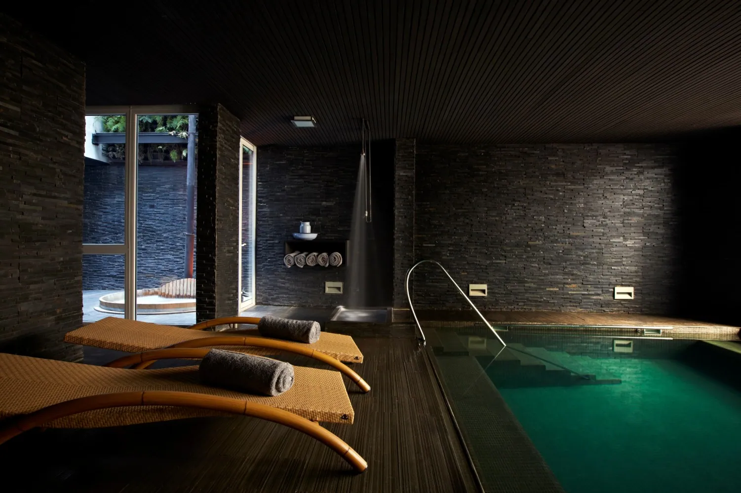 Piscina interior temperada de Spa Alegre con paredes de pizarra